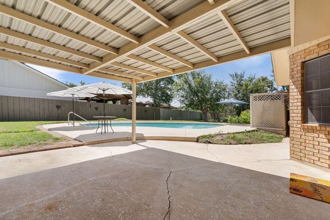 View of swimming pool featuring a fenced backyard and a patio area | Image 27