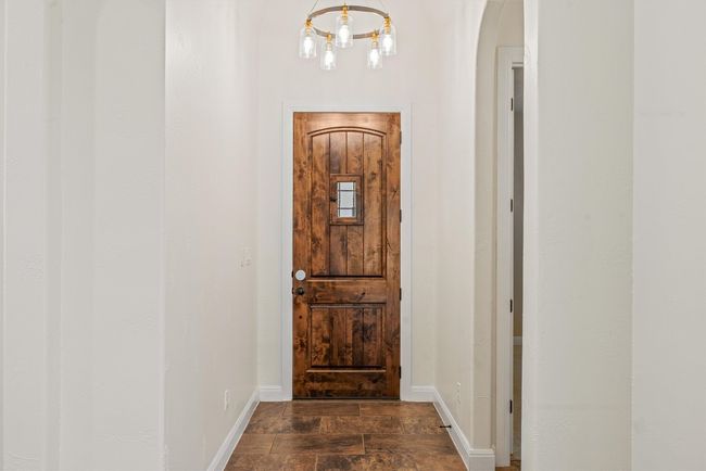 Entryway with a modern chandelier and arched walkways | Image 15