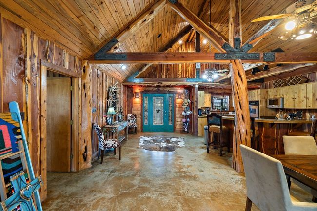Foyer entrance featuring wooden walls, a ceiling fan, a dry bar, concrete flooring, and wooden ceiling | Image 24