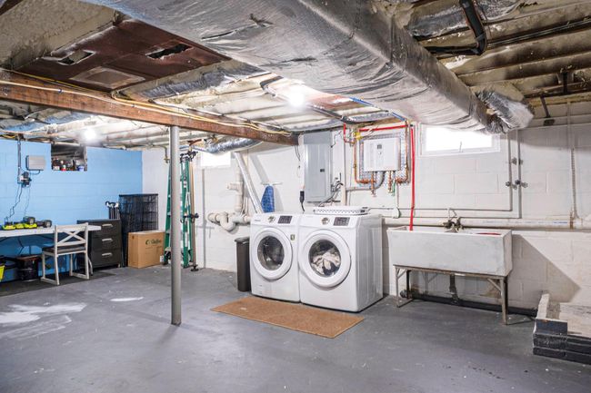 Basement with electric panel, washer and clothes dryer, and a sink | Image 35