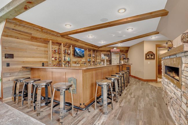 Massive bar area with ample seating, sleek countertops, and plenty of space for entertaining guests in style. | Image 67
