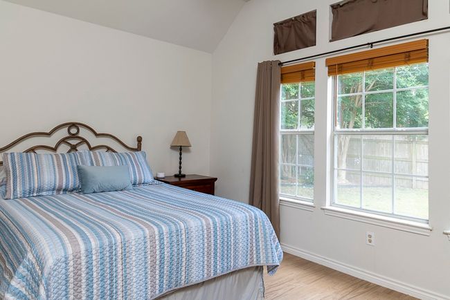 Bedroom featuring multiple windows, vaulted ceiling, and wood finished floors | Image 14
