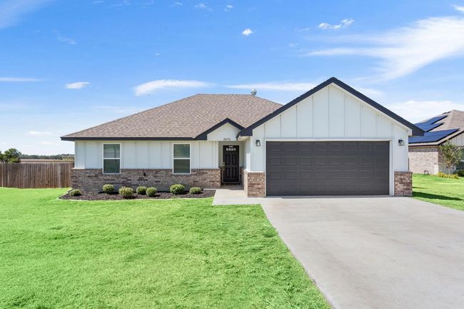 View of front of house featuring roof with shingles, brick siding, and board and batten siding | Image 5