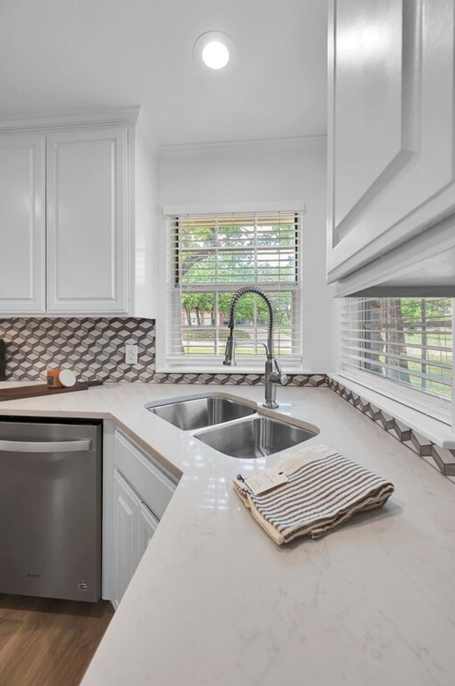 Kitchen featuring stainless steel appliances, and freshly painted white cabinetry | Image 13