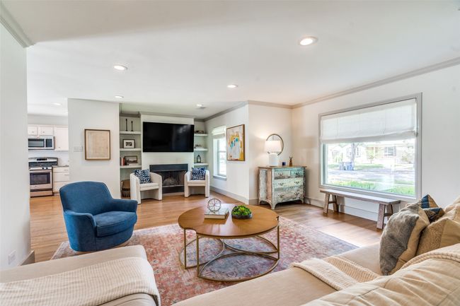 Living room featuring ornamental molding, light wood-style floors, recessed lighting, a fireplace, and baseboards | Image 4