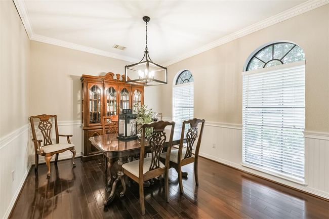 Elegant dining room featuring a new light fixture, exquisite wood floors, and expansive windows. | Image 17