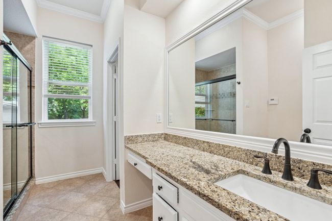 Bathroom featuring ornamental molding, a stall shower, vanity, and tile patterned floors | Image 16