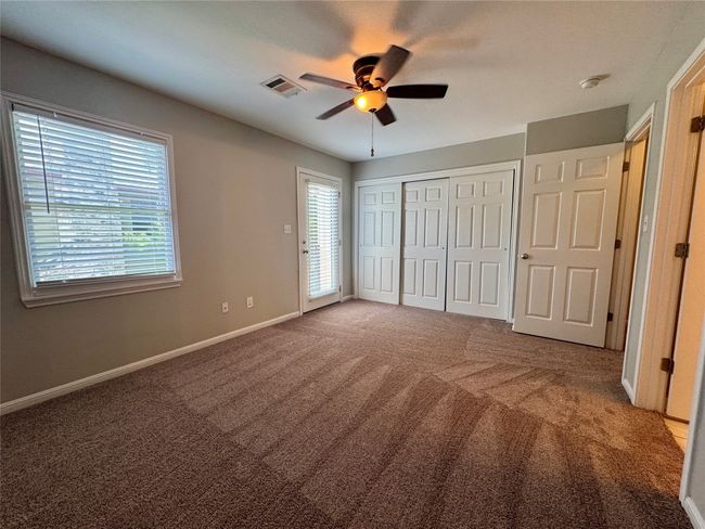 Unfurnished bedroom with carpet floors, ceiling fan, and a closet | Image 16