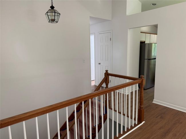 Hall with an upstairs landing and dark wood-style floors | Image 7