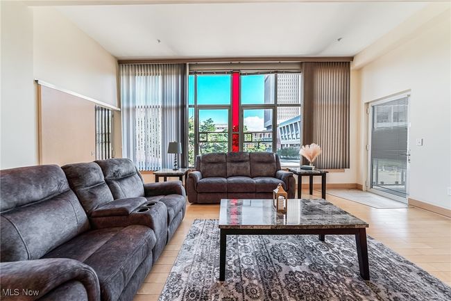 Great room with light wood finished floors and balcony access. | Image 7