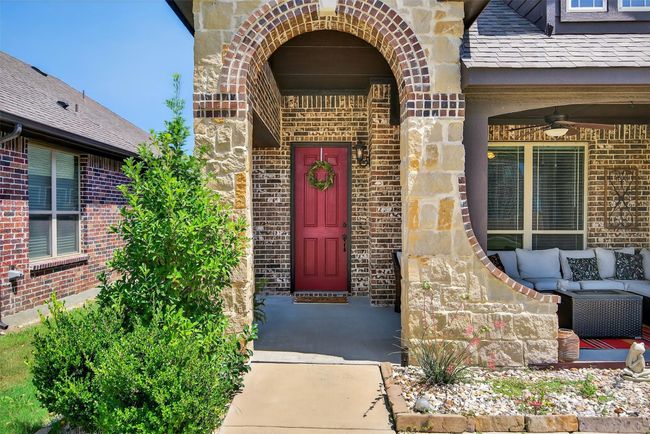 Property entrance featuring ceiling fan, brick siding, stone siding, and an outdoor living space | Image 5