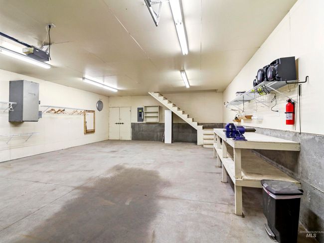 Garage featuring a workshop area, electric panel, and a garage door opener | Image 39