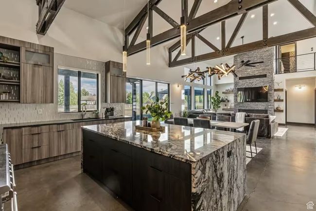Kitchen featuring finished concrete flooring, modern cabinets, a sink, and decorative backsplash | Image 11
