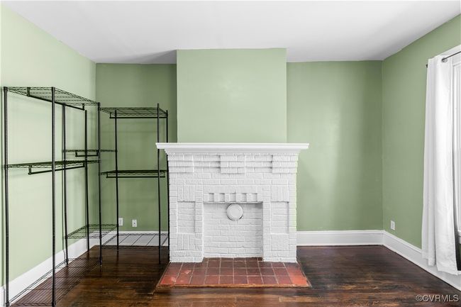 Unfurnished living room with hardwood / wood-style floors, baseboards, and a brick fireplace | Image 25