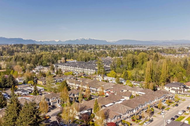 Aerial view of property's location with a mountainous background, nearby suburban area, and a heavily wooded area | Image 4