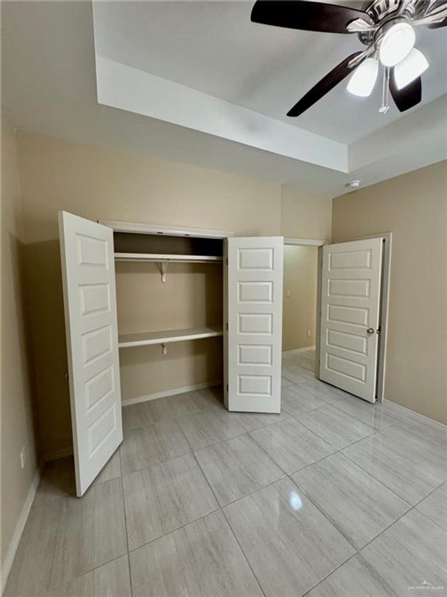 Vew of bedroom closets, ceiling fan, and a raised ceiling | Image 11