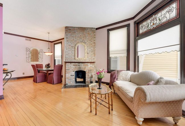 A working wood-burning brick fireplace makes the space cozy and serves to separate the living room from the dining room. | Image 8