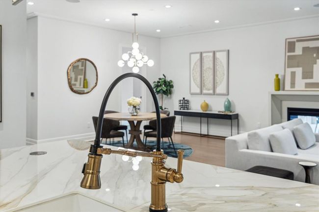 [Kitchen] Another standout upgrade... the designer brass faucet with pulldown sprayer. The kitchen island also houses a Fisher and Paykel double drawer dishwasher, along with additional cabinets and drawers | Image 15