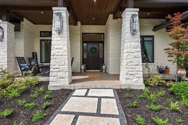 Inviting entry featuring covered porch and stone siding | Image 4