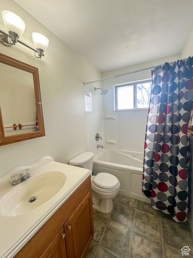 Full bathroom featuring vanity, shower / bath combination with curtain, and toilet | Image 8
