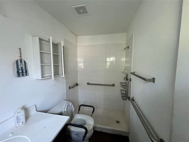 Bathroom featuring tiled shower, toilet, and vanity | Image 16