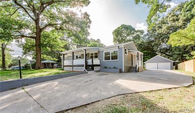 View of front of home with a garage, covered porch, an outdoor structure, and a front yard | Image 2