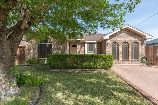 Ranch-style home featuring brick siding, a front lawn, and fence | Image 13