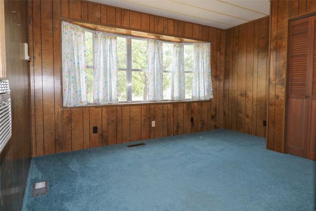 Spare room with wood walls and carpet flooring | Image 15