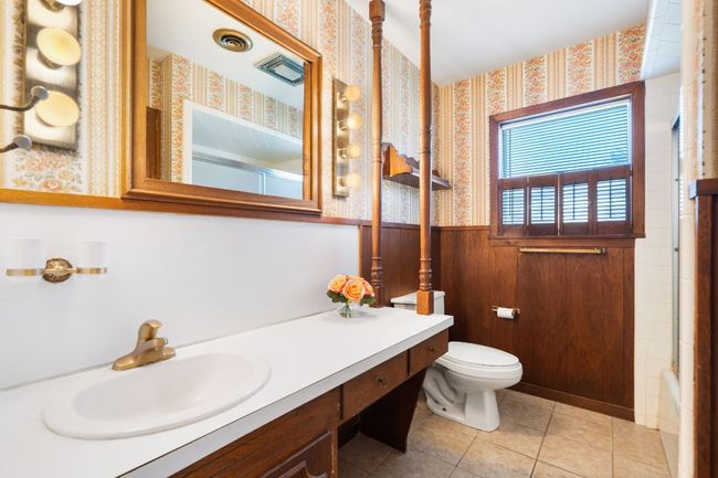 Full bath featuring wainscoting, vanity, tile patterned floors, and wallpapered walls | Image 22