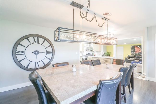 Dining room featuring dark wood finished floors and a chandelier | Image 24