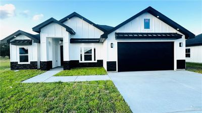 Modern inspired farmhouse featuring a front lawn and a garage | Image 1