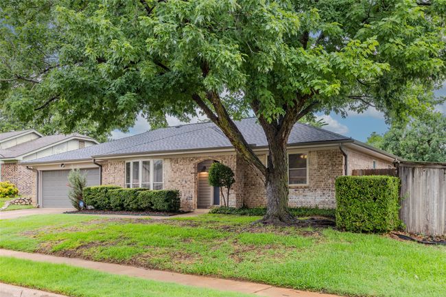 View of front of property with brick siding, a garage, driveway, and a shingled roof | Image 4