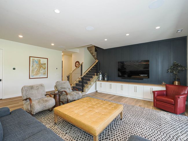 Living room featuring stairs, recessed lighting, light wood-type flooring, an accent wall, and a decorative wall | Image 69