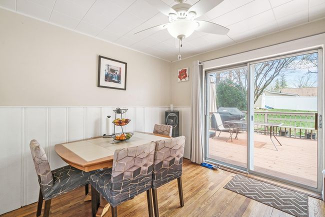 Dining room featuring light wood-type flooring, wainscoting, ceiling fan, and a decorative wall | Image 10