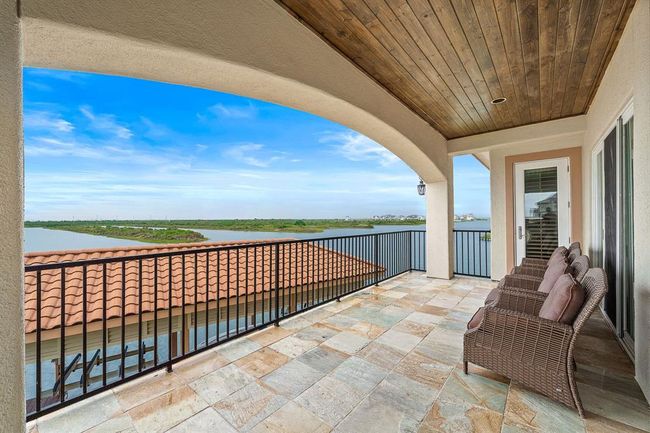 Enjoy seamless indoor-outdoor living as the living room, kitchen, and primary suite all offer access to a covered terrace overlooking the Marina Channel and West Bay | Image 20
