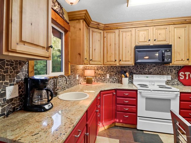 Kitchen featuring white electric range, black microwave, and backsplash | Image 24