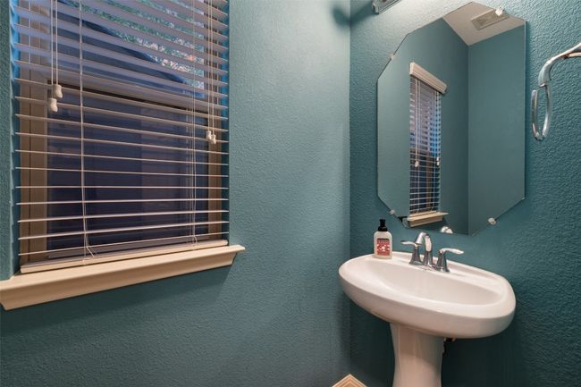 Hall from garage has half bath, walk in pantry and laundry room with medium dog door and large window. | Image 13