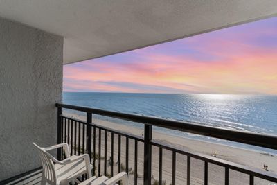 Balcony at dusk featuring a water view and a view of the beach | Image 2