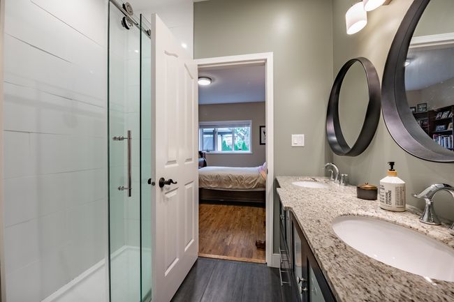 Ensuite bathroom with double vanity, a tile shower, and wood finished floors | Image 19