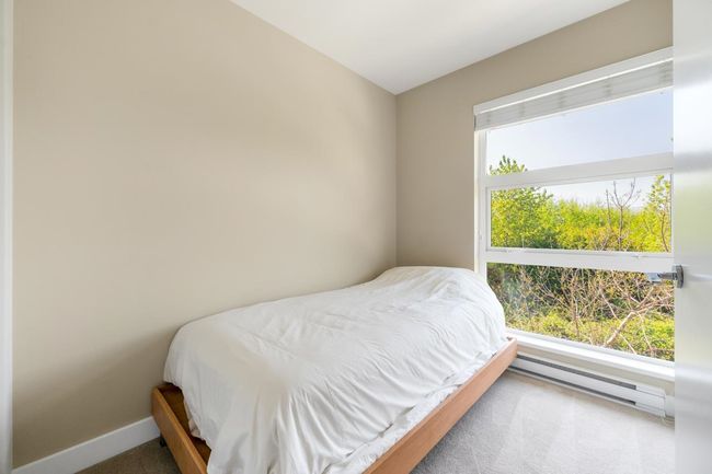 Bedroom with a baseboard heating unit, carpet flooring, and baseboards | Image 16