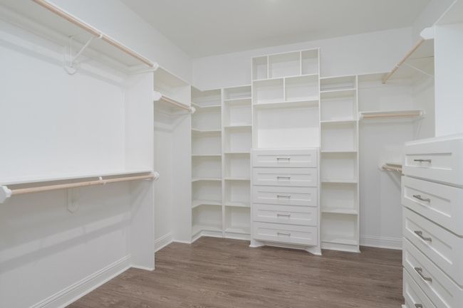 Walk in closet featuring dark wood finished floors | Image 25