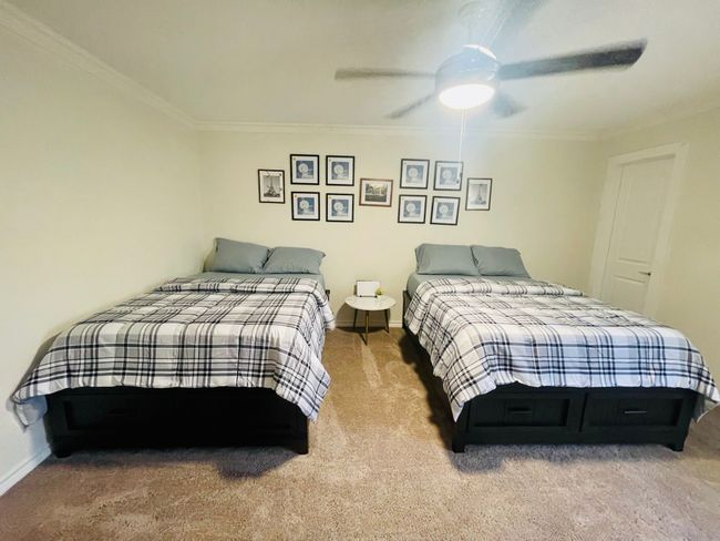 Carpeted bedroom with crown molding, baseboards, and ceiling fan | Image 13