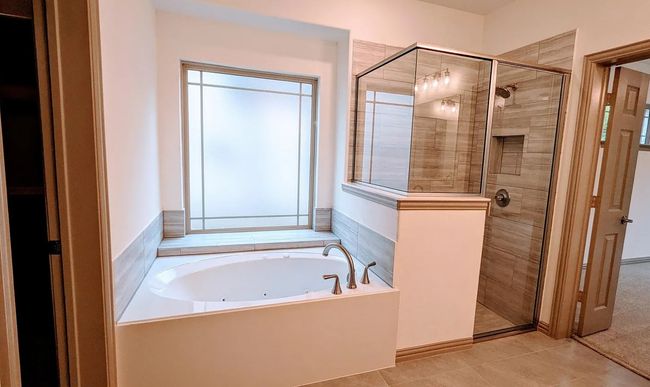 Bathroom with a whirlpool tub, a shower stall, and tile patterned flooring | Image 19