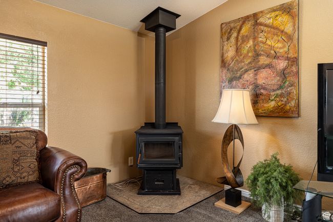 Interior space featuring carpet floors and a wood stove | Image 6