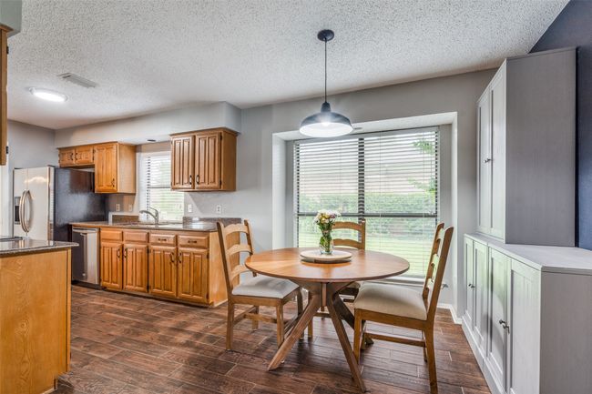 Dining area featuring dark wood finished floors and a textured ceiling | Image 9
