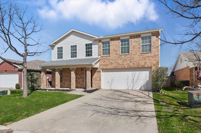 Traditional-style home featuring brick siding, an attached garage, a porch, and concrete driveway | Image 4