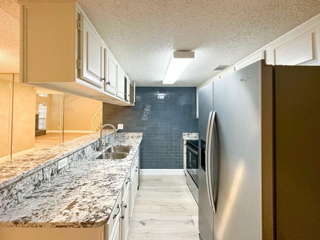 Kitchen featuring stainless steel fridge, a sink, light wood-style flooring, electric range, and a textured ceiling | Image 5