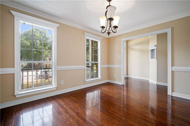 Empty room featuring a chandelier, plenty of natural light, hardwood / wood-style floors, and crown molding | Image 15