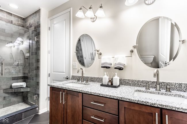 bathroom with double vanity, a stall shower, and tile patterned flooring | Image 23