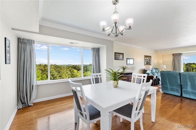 Dining space with a chandelier, crown molding, visible vents, and baseboards | Image 8